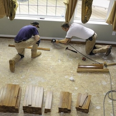 Multiple people working with on flooring